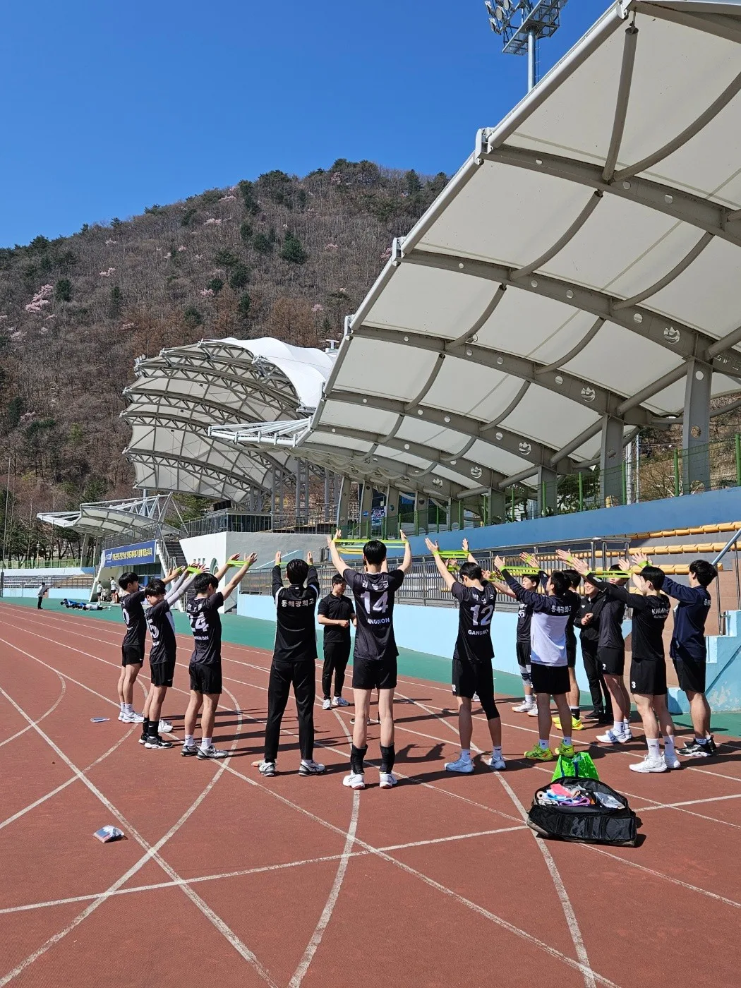 야외에서 밴드를 이용해 함께 스트레칭하는 단체 수업
